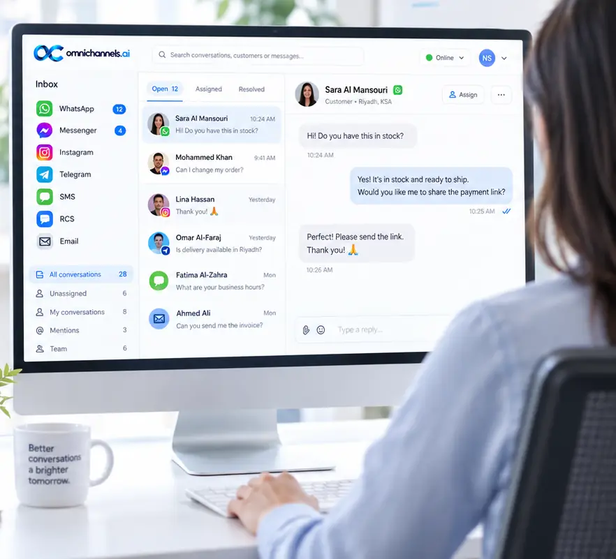 A support agent at a bright desk works in the OmniChannels.ai inbox, with conversations from several channels listed beside an open chat.